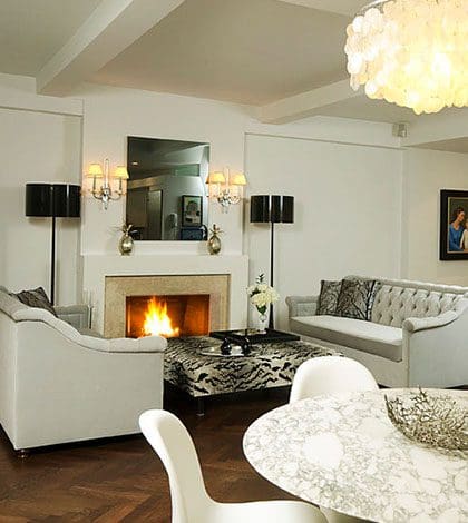 A living room with white furniture and fireplace.