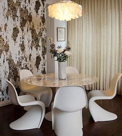 A dining room with white chairs and a table