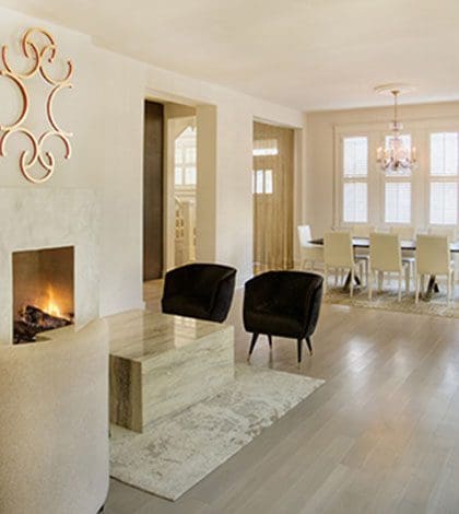 A living room with a fireplace and chairs