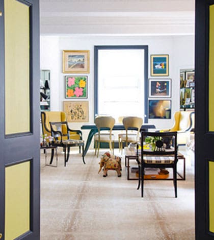 A living room with yellow walls and black trim.