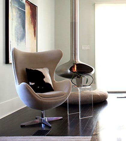 A chair and fireplace in a room with wood floors.